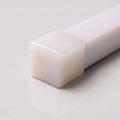 Close-up of a closed opal silicone end cap for 15x15mm LED neon flex on a light grey background