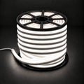 Natural white 4000K 8×16mm 220–240V wireless IP65 LED neon flex lit reel with open-spoke black top, visible light inside, end cap and cable on dark charcoal