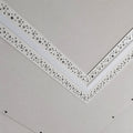 Straight plaster-in profile screwed into a plasterboard ceiling at a mitred corner before skimming