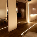 Black LED surface profile installed under a wall cabinet lighting a worktop