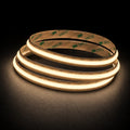 2700K Free Cut COB LED strip 24V 8mm IP20 illuminated coil on black background