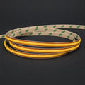 ATOM LED FreeCut COB LED strip switched-off coil illustration with golden PCB and adhesive backing on charcoal background