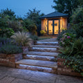 Blue RGB neon flex recessed under outdoor garden step nosings, illuminating the stone below