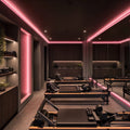 Pink SCOB LED strip lighting installed in a modern Pilates studio — illustrative interior