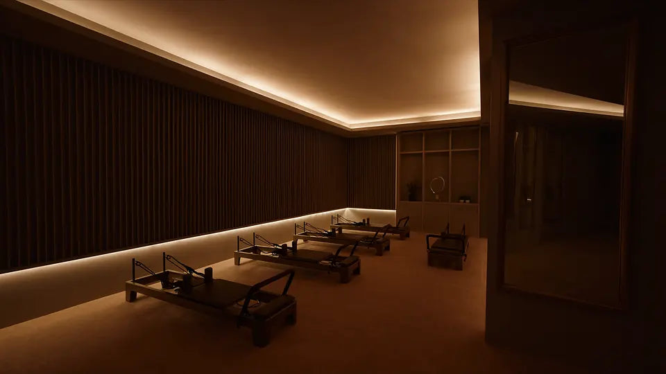 Premium Pilates studio with concealed warm-white COB LED lighting around the ceiling and wall