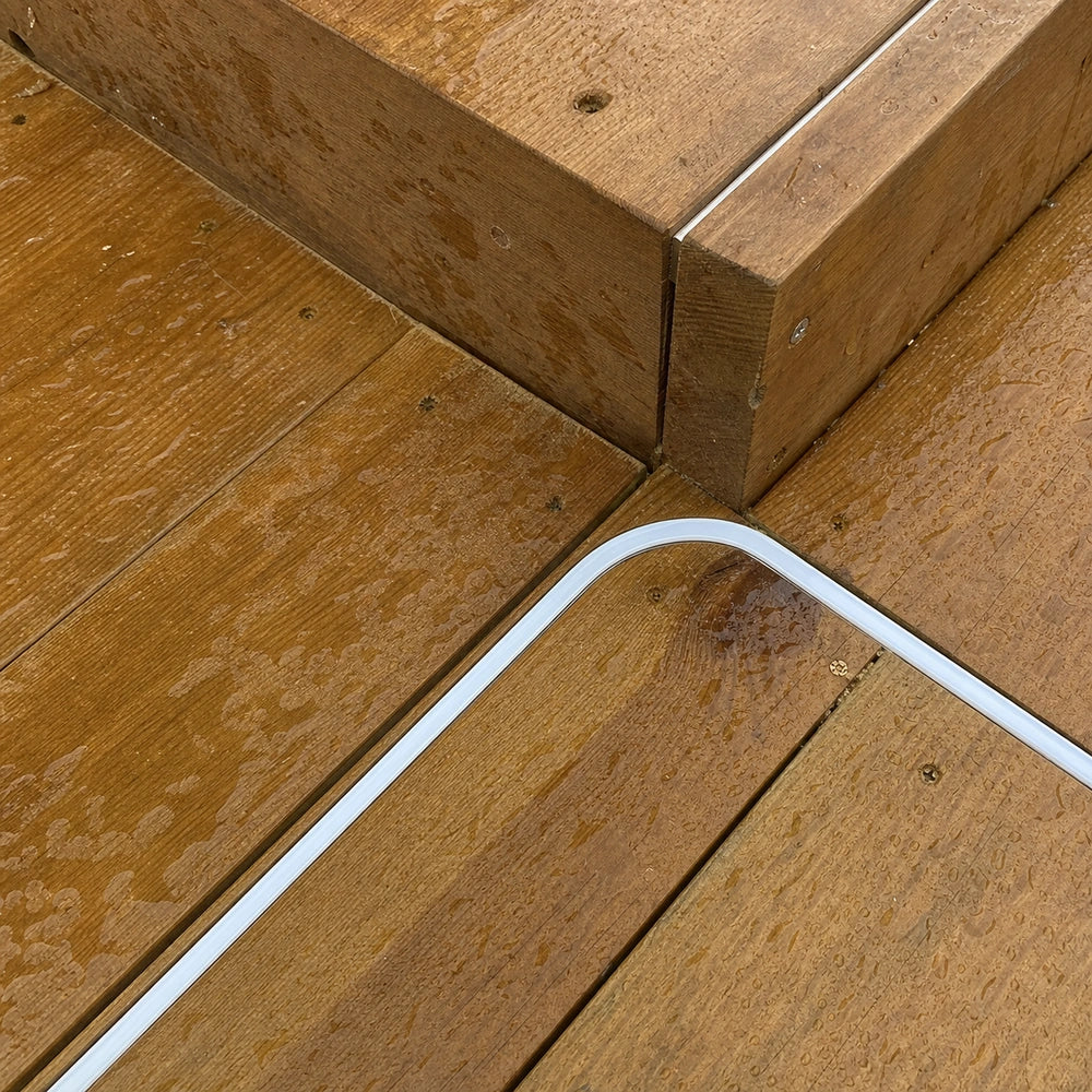 Neon flex turning a flat corner around the edge of a wet timber deck