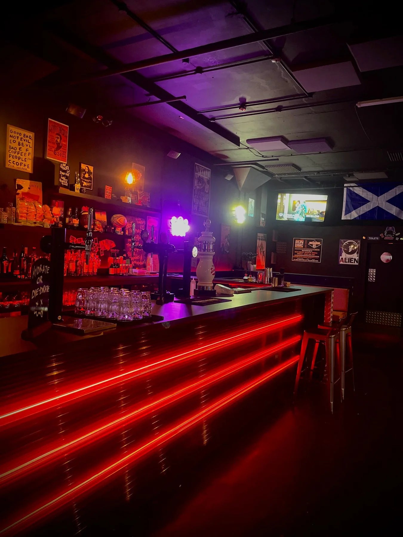 Angled view of a Manchester bar with red RGB COB LED strip lighting across the bar front