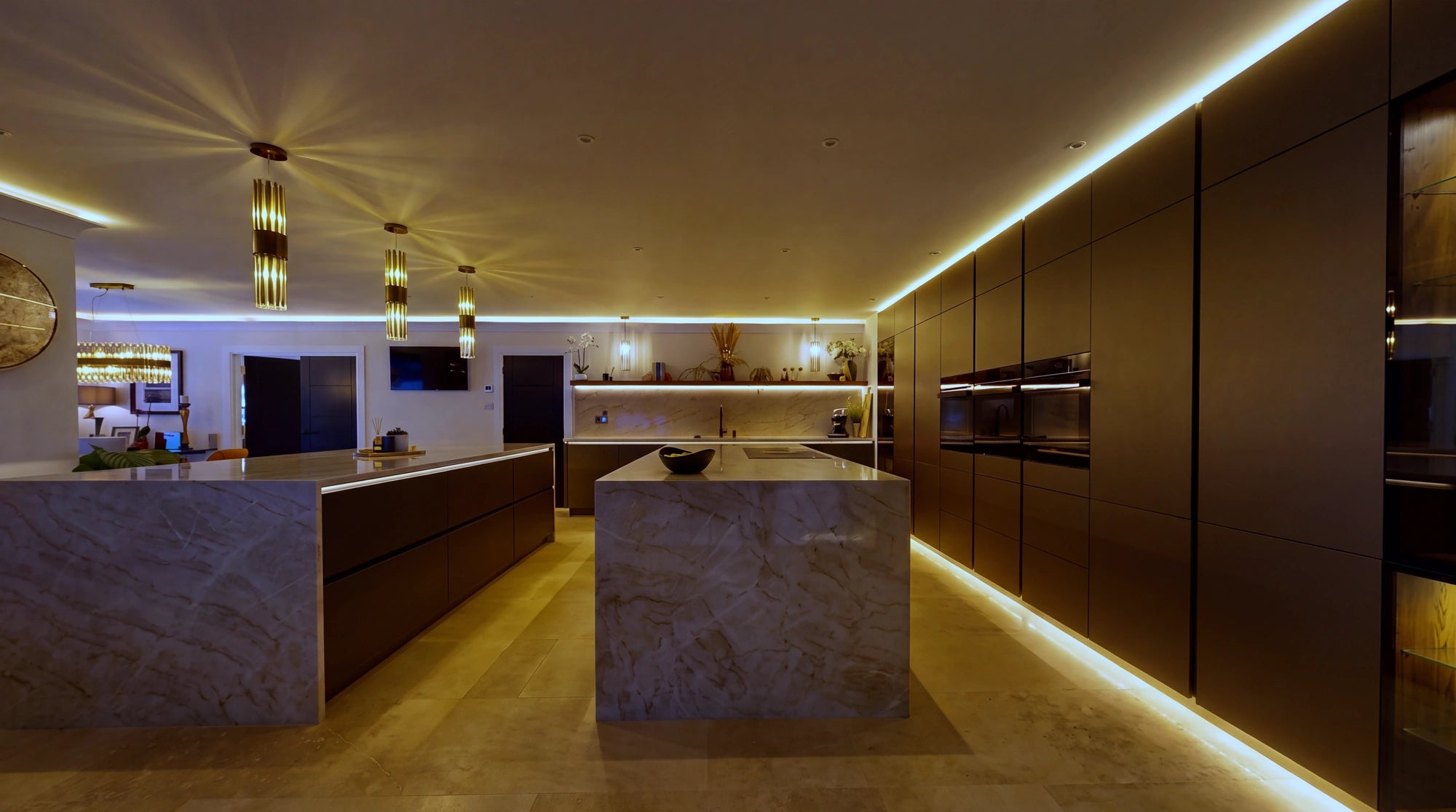 Tall cabinet run and second island with continuous warm white COB LED under the worktop overhang and plinth-level light