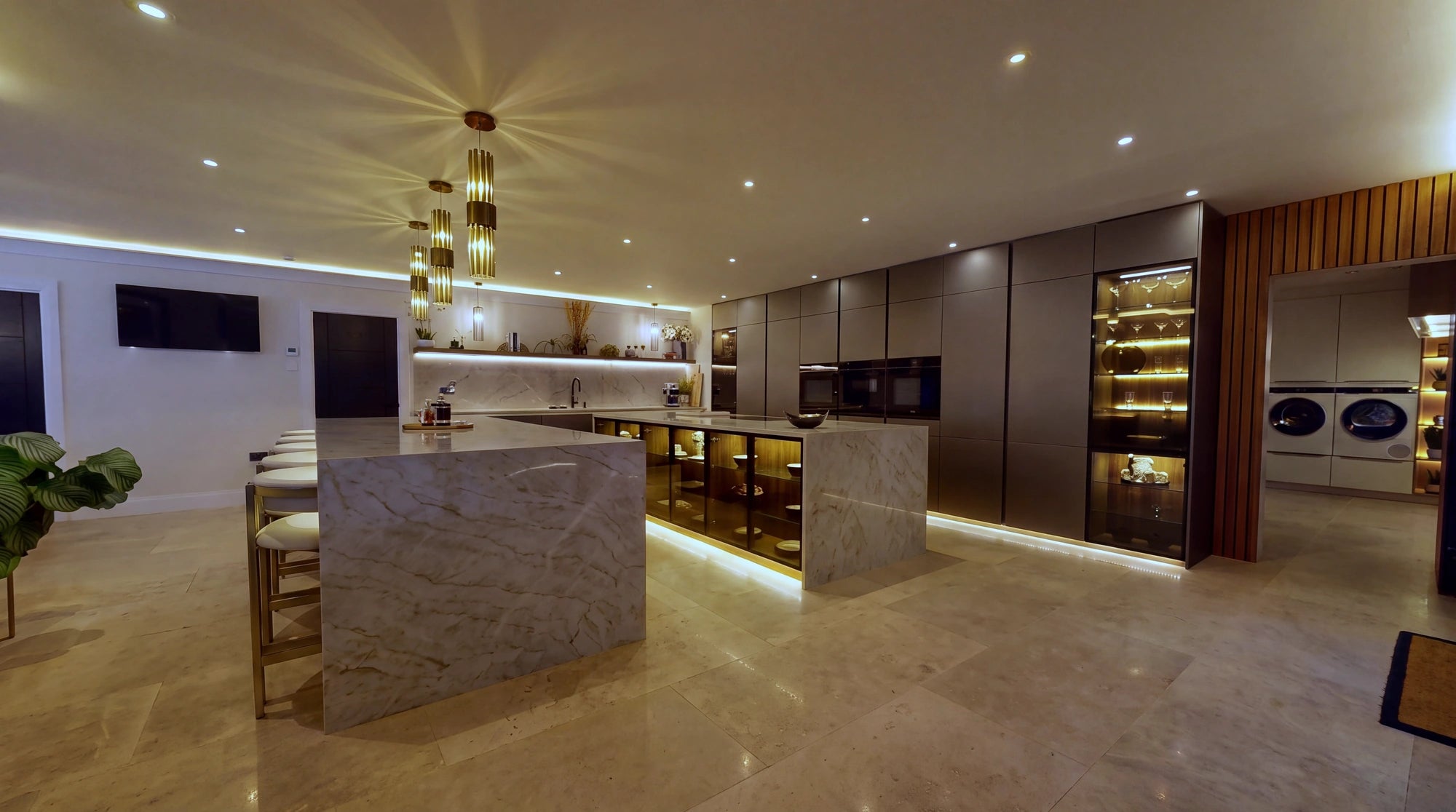 Marble island with bar stools, lit glass display cabinets and COB LED strip running through the cabinetry