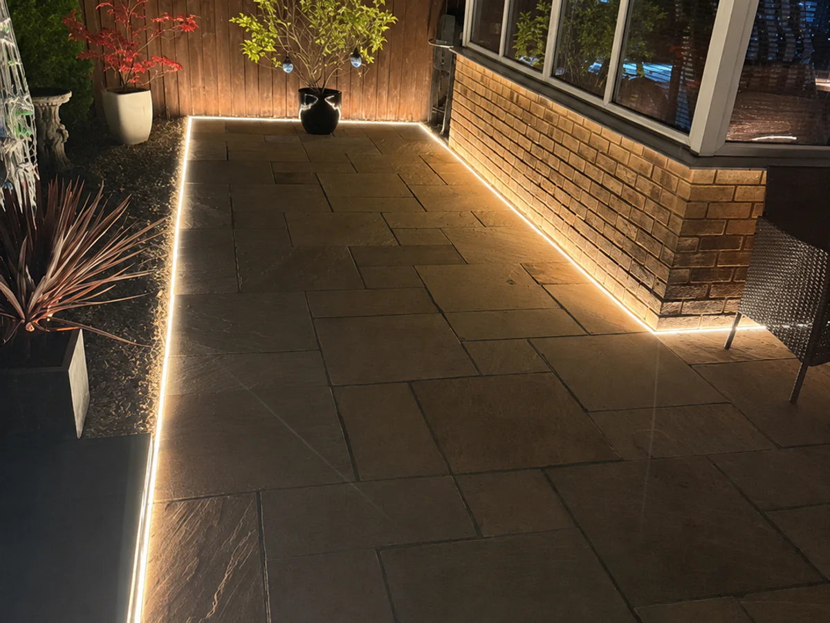 Warm white recessed neon flex following a paved garden perimeter