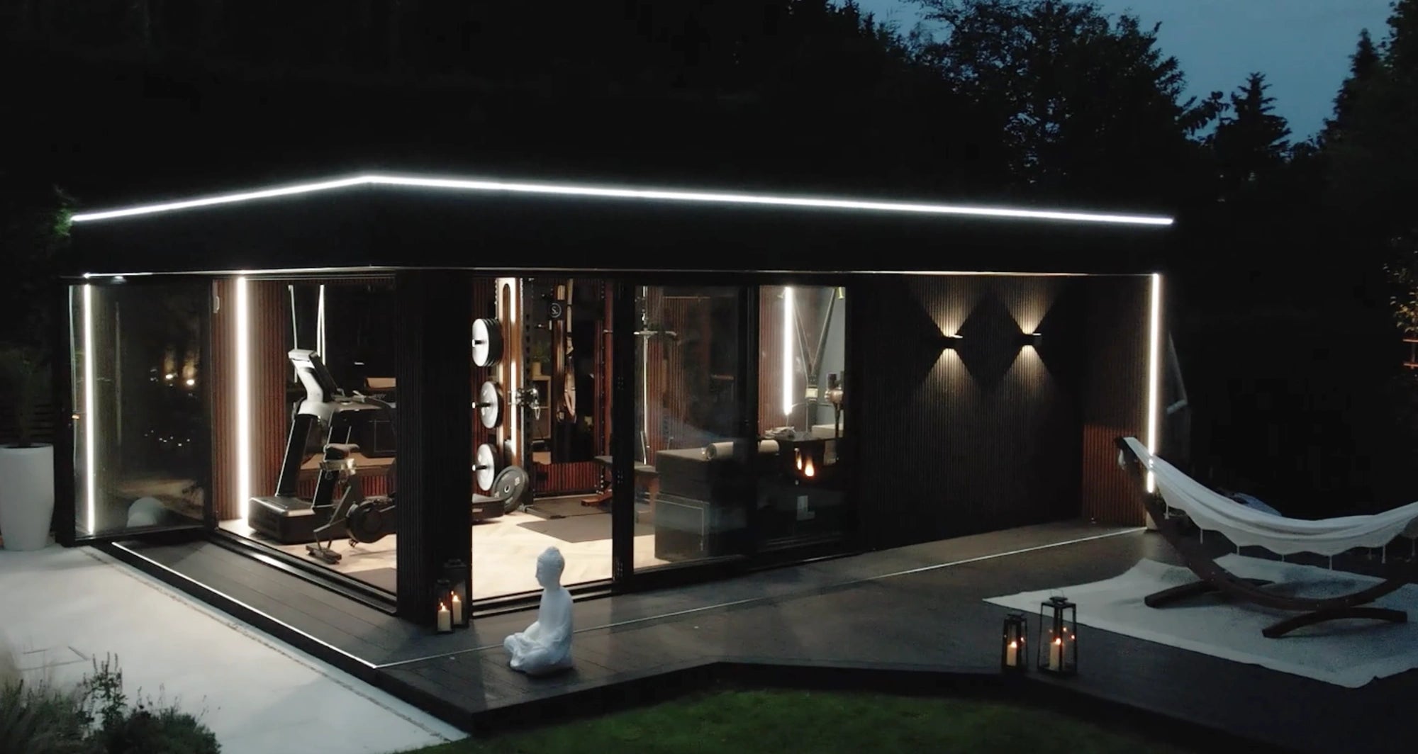 Garden room lit at night with hammock on the patio and warm COB interior wash