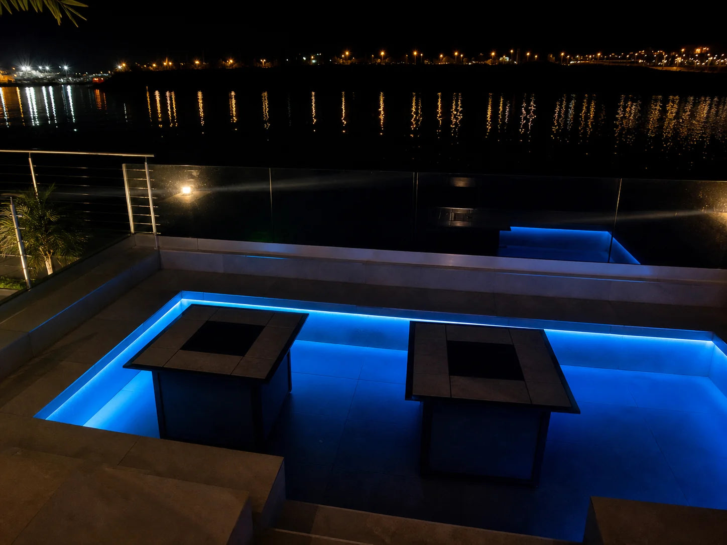 Outdoor terrace seating perimeter lit in blue digital pixel RGB neon flex